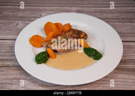 Rezept für gebackene Lammschulter mit Kartoffelpüree, Süßkartoffeln und Karotten, Pfeffersauce, Cognac und frischer Creme Stockfoto