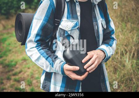 Nahaufnahme, eine Flasche Wasser in den Händen eines Reisenden. Stockfoto
