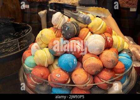 In der Vitrine sind Süßigkeiten von Macaron zu sehen. Bunte Bonbons oder Makronen. Stockfoto