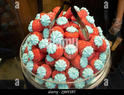 Handwerkliche Süßigkeiten im Süßwarenladen in istanbul. In der Vitrine sind Süßigkeiten von Macaron zu sehen. Erdbeerrot, Bonbons und Makronen. Stockfoto