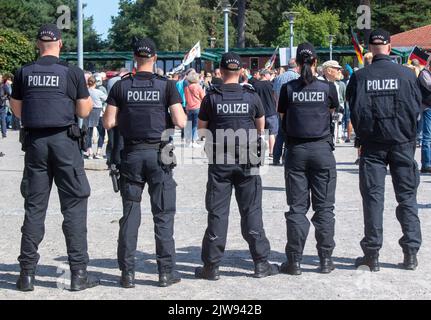 Lubmin, Deutschland. 04. September 2022. Polizeibeamte begleiten eine Demonstration gegen die Russland-Sanktionen. Am selben Tag findet in Lubmin eine Demonstration zur Inbetriebnahme der Nord Stream 2 statt. Bisher wurde Lubmin hauptsächlich dazu verwendet, russisches Gas aus der Ostsee-Pipeline Nord Stream 1 zu landen, die seitdem von Russland geschlossen wurde, und es dann an andere Teile Deutschlands und Europas weiterzuleiten. Auch die Nord Stream 2-Pipeline, die nicht in Betrieb ist, endet hier. Quelle: Stefan Sauer/dpa/Alamy Live News Stockfoto