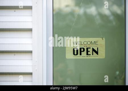 Die Wiedereröffnung eines Kleinbetriebs nach dem covid-19-Notfall beendete die Sperrung und Quarantäne. Ein Holzgeschäftszeichen, das besagt, dass wir jetzt offen sind Stockfoto