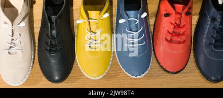 Foto von bunten Lederschuhen im Geschäft. Vielfalt der bunten Schuhe Stockfoto