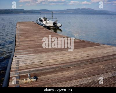 An einem hellen Frühlingsnachmittag im März liegt ein aufblasbares Schlauchboot vor dem Anlegesteg bei Otter Ferry und blickt nach Norden über Loch Fyne. Argyll und Bute Stockfoto