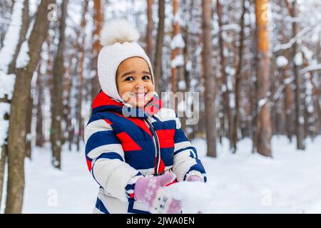 Kleines Mädchen spielt am verschneiten Wintertag im Park Schlittenfahrt den Hügel hinunter Stockfoto