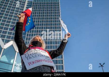 Warszawa, Polen. 11.. November 2021. Ein Aktivist hält während des Unabhängigkeitsmarsches eine Fahne und Plakate. Am 11. November wird der unabhängigkeitsmarsch jährlich von radikalen nationalen Kreisen organisiert. Der marsch weckt in der Gesellschaft viele Ängste und Emotionen aufgrund der Verluste, die Warschau nach diesem marsch in den vergangenen Jahren erlitten hat, kamen an diesem Tag Polizeieinheiten aus allen Polen in die Hauptstadt, um Ordnung und Sicherheit der Demonstranten zu gewährleisten. (Foto von Pawe? Wróblewski/SOPA Images/Sipa USA) Quelle: SIPA USA/Alamy Live News Stockfoto