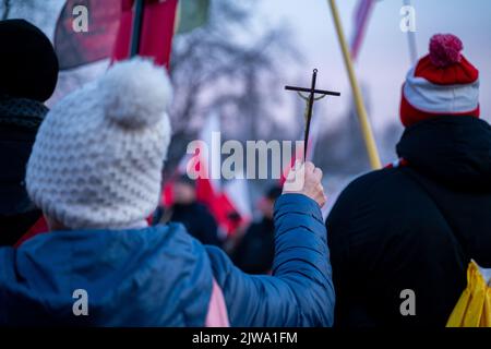 Warszawa, Polen. 11.. November 2021. Ein Teilnehmer hält während des Unabhängigkeitsmarsches ein Kreuz. Am 11. November wird der unabhängigkeitsmarsch jährlich von radikalen nationalen Kreisen organisiert. Der marsch weckt in der Gesellschaft viele Ängste und Emotionen aufgrund der Verluste, die Warschau nach diesem marsch in den vergangenen Jahren erlitten hat, kamen an diesem Tag Polizeieinheiten aus allen Polen in die Hauptstadt, um Ordnung und Sicherheit der Demonstranten zu gewährleisten. (Foto von Pawe? Wróblewski/SOPA Images/Sipa USA) Quelle: SIPA USA/Alamy Live News Stockfoto