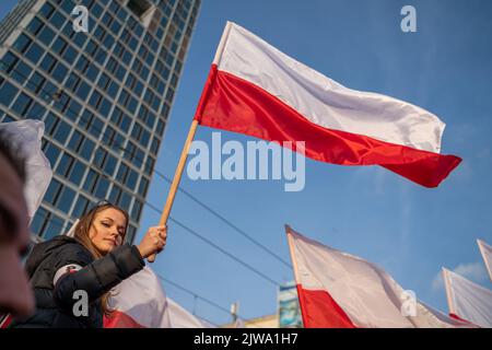 Warszawa, Polen. 11.. November 2021. Eine Frau hält während des Unabhängigkeitsmarsches eine polnische Flagge. Am 11. November wird der unabhängigkeitsmarsch jährlich von radikalen nationalen Kreisen organisiert. Der marsch weckt in der Gesellschaft viele Ängste und Emotionen aufgrund der Verluste, die Warschau nach diesem marsch in den vergangenen Jahren erlitten hat, kamen an diesem Tag Polizeieinheiten aus allen Polen in die Hauptstadt, um Ordnung und Sicherheit der Demonstranten zu gewährleisten. (Foto von Pawe? Wróblewski/SOPA Images/Sipa USA) Quelle: SIPA USA/Alamy Live News Stockfoto