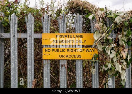 Gelbe Schilder mit der Aufschrift - Private Lane Residents Only kein öffentliches Wegerecht oder Zugangsrecht auf Metallzaun in Trowbridge, Wiltshire, England, Großbritannien Stockfoto