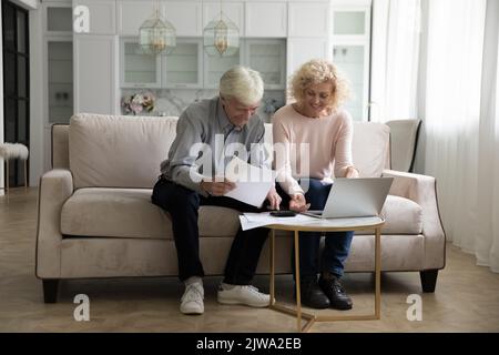 Glückliches älteres Paar, das zu Hause zusammen Hausarbeit macht Stockfoto