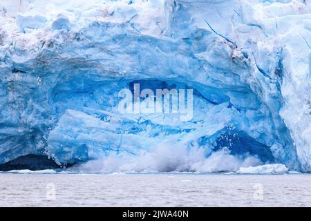 Riesige Eisbrocken stürzen in das Meer mit einem enormen Spritzer, während der monacobreen-Gletscher kälbt Stockfoto