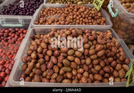 Selektiver Fokus auf grüne Oliven auf einem Bauernmarkt. Olivensorten. Nahaufnahme Stockfoto