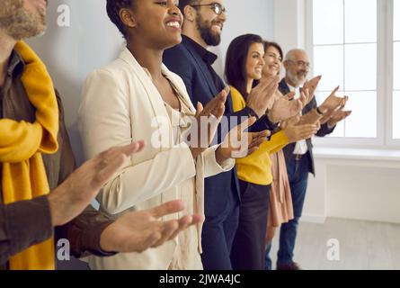 Glückliche, vielfältige Mitarbeiter klatschen in die Hände und zeigen Anerkennung Stockfoto