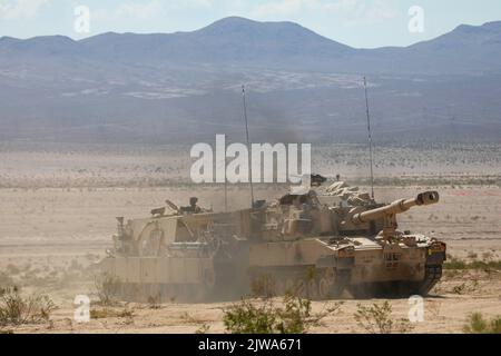 US-Soldaten, die 2. Bataillon, 70. Panzerregiment, 2. Panzerbrigade-Kampfteam, 1. Infanterie-Division zugewiesen wurden, transportieren einen M109 Paladin mit einem M88 Hercules Recovery Vehicle während der entscheidenden Aktionsdrehung 22-09 im National Training Center, Fort Irwin, Kalifornien, 14. August 2022 (USA Armeefoto von Sgt. Ryan Gosselin, Operations Group, National Training Center) Stockfoto