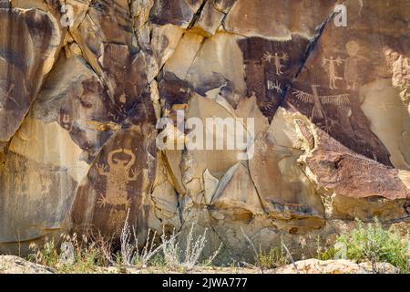 Felskunst der Petroglyphen in Legend Rock State Archaeological Site, Wyoming - geschnitzte Sandsteinplatten mit anthropomorphen und zoomorphen Figuren erstellt b Stockfoto