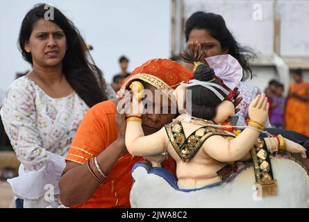 Mumbai, Indien. 04. September 2022. Eine eifrige Frau flüstert ihrem Wunsch ins Ohr des elefantenköpfigen Hindu-gottes Ganesh, bevor das Idol zum Eintauchen am Juhu-Strand in Mumbai getragen wird. Ganapati Immersion ist ein zehntägiges Festival, das am 9.. September 2022 abgeschlossen wurde. Kredit: SOPA Images Limited/Alamy Live Nachrichten Stockfoto