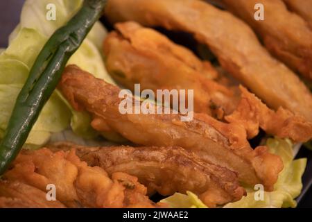 Indian Street Food Crispy Fried Potato Wedges werden auch als Aloo Bhajji, Alu Bajji, Aaloo Pakoda oder Pakora aus Bengalen Gram Mehl Besan Coat Stockfoto