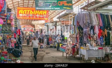 Osch, Kirgisistan - 2022. Mai: Menschen, die im Osh Bazaar einkaufen, dem Hauptnahrungsmarkt, auf dem sich die Bewohner der Osch treffen, um ihre Waren zu kaufen und zu verkaufen. Stände Stockfoto