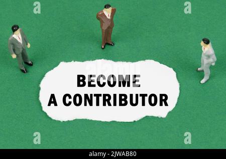 Auf der grünen Oberfläche gibt es Figuren von Geschäftsleuten und es ist zerrissenes Papier mit der Aufschrift -Werden Sie ein Beitragender Stockfoto