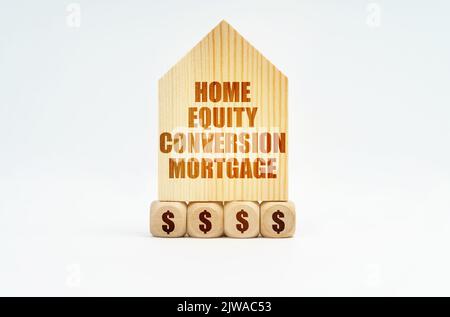 Auf einer weißen Oberfläche steht ein Holzmodell eines Hauses mit der Aufschrift - Home Equity Conversion Mortgage Stockfoto