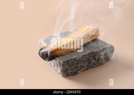 Palo Santo Räucherstäbchen, die auf Stein brennen. Stockfoto