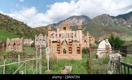 Osch, Kirgisistan - 2022. Mai: Ein kirgisisches Grab auf einem traditionellen muslimischen Friedhof Stockfoto