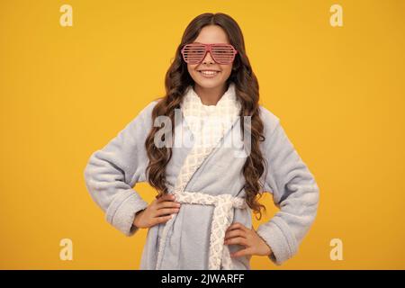 Porträt von lustigen Teenager-Mädchen in lustigen Brillen und Pyjama oder zu Hause Bademantel Gefühl Spaß isoliert auf gelbem Hintergrund. Stockfoto