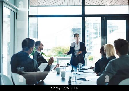 Harte Arbeit sorgt für eine reibungslose Fahrt. Eine attraktive junge Geschäftsfrau, die eine Präsentation im Sitzungssaal gibt. Stockfoto