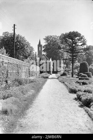 Blick in den Garten der Burg Amerongen (Drostestraat) in Amerongen, mit der Orangerie und dem Turm der St. Andrieskerk (Hof 16) im Hintergrund. Stockfoto