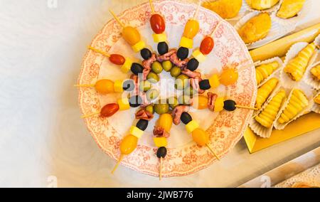 Blick von oben auf ein Tablett mit Käse und Schinken auf einem Buffettisch mit anderen Snacks Stockfoto