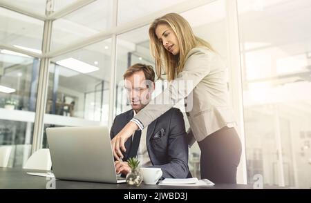 Austausch von Ideen, Austausch von Erfolgen. Zwei Führungskräfte arbeiten in einem Büro zusammen. Stockfoto