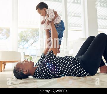 Die wichtigste Person in ihrem Leben. Eine Mutter hält ihr Baby in der Luft. Stockfoto