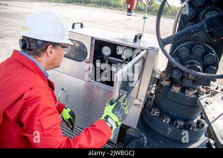 Vechta, Deutschland. 26. August 2022. Peter Thie von ExxonMobil überprüft die Kontaktdruckmanometer am Eruptionskreuz vom Erdgasfeld Goldenstedt Z23. (To dpa ''Kampf um jeden Kubikmeter': Deutsche Gasproduktion und ihre Grenzen') Quelle: Sina Schuldt/dpa/Alamy Live News Stockfoto