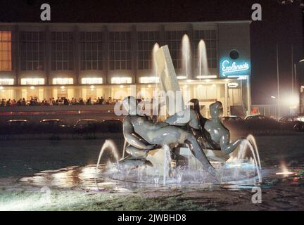 Blick auf die Stadsschouwburg bei Nacht (Lucasbolwerk) in Utrecht mit dem Brunnen im Vordergrund mit der Skulpturengruppe Fest des Muzen. Stockfoto