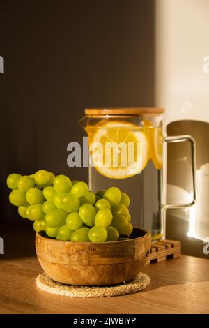 Grüne Trauben liegen auf Öko-Gericht. Umweltfreundliche Wahl und freundliche Natur. Das Konzept der Welt ohne plastikfreien und sauberen Planeten. Umweltfreundliches Geschirr aus natürlichen Materialien Stockfoto
