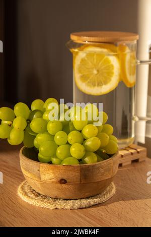 Grüne Trauben liegen auf Öko-Gericht. Umweltfreundliche Wahl und freundliche Natur. Das Konzept der Welt ohne plastikfreien und sauberen Planeten. Umweltfreundliches Geschirr aus natürlichen Materialien Stockfoto