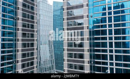 Luftansicht des Gebäudes mit blauen Fenstern, das Wolkenkratzer in der Stadt Jakarta widerspiegelt Stockfoto