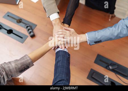Draufsicht auf Gruppenmitarbeiter, die als Konzept der Unternehmenseinheit zusammengeschichtet sind Stockfoto