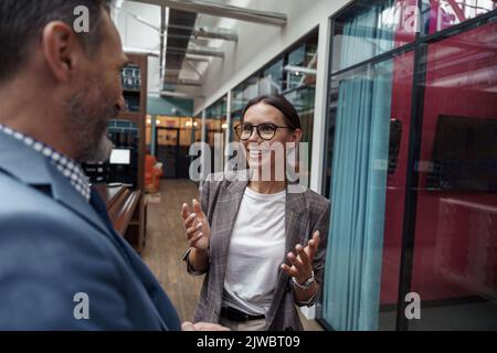 Zwei Geschäftsleute, die während der Pause im Büro stehen, sprechen. Teamwork-Konzept Stockfoto