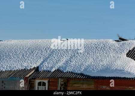 Ein Eisblock hängt vom Dach des Hauses Stockfoto