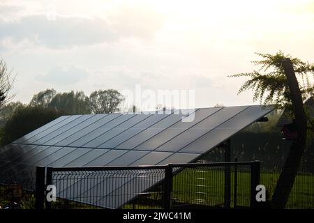 Neues ecologic Haus mit Sonnenkollektoren Alternative zu konventioneller Energie. Die Batterie wird von einer Solarzelle geladen Werbung Grüne Energie Nachhaltiges Leben Erneuerbare alternative Energie Stockfoto