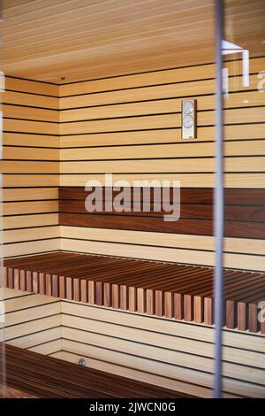 Moderne hölzerne Innenausstattung der schönen und sauberen Sauna mit elektrischer Heizung. Stockfoto