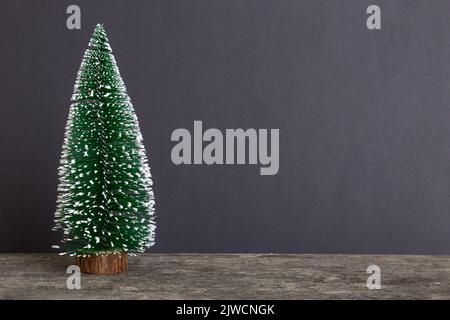 Ein kleiner Weihnachtsbaum auf farbigem Hintergrund. Neujahr Dekoration mit Kopierraum. Stockfoto