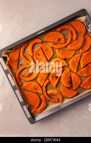 Gehackter, gebackener, süßer Butternut-Kürbis auf einem Backblech, Draufsicht Stockfoto