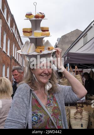 Frau trägt ihren Nachmittagstee-Hut beim Bridport hat Festival Dorset 2022 Stockfoto