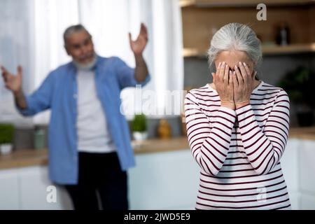 Innenpolitische Konflikte. Porträt Eines Älteren Ehepaares, Das Sich Im Kücheninneren Streite, Stockfoto