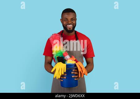 Frühjahrsputz. Portrait Von Smiling Black Cleaner Guy Holding Korb Von Waschmitteln Stockfoto