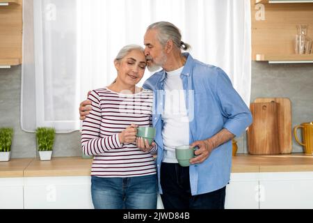 Portrait Of Loving Senior Ehepartner Entspannen Mit Kaffee In Der Küche Innenraum Stockfoto
