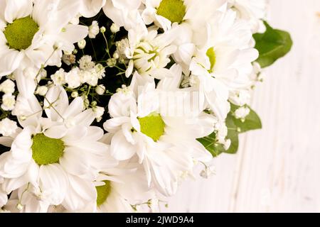 Bouquet von weißen KamillenChrysanthemen auf Holzhintergrund. Geschenk Blumen Korb für den Urlaub Stockfoto