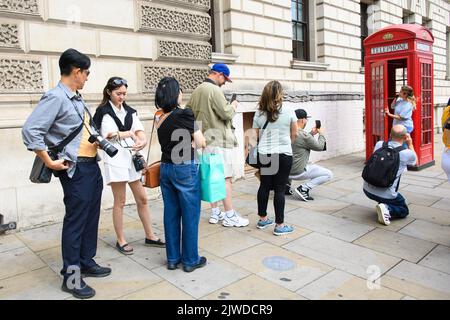 London, Großbritannien. 5. September 2022. Touristen stehen vor einer roten Londoner Telefonbox in Westminster, London, an, um Fotos zu machen. Bilddatum: Montag, 5. September 2022. Bildnachweis sollte lauten: Matt Crossick/Empics/Alamy Live News Stockfoto